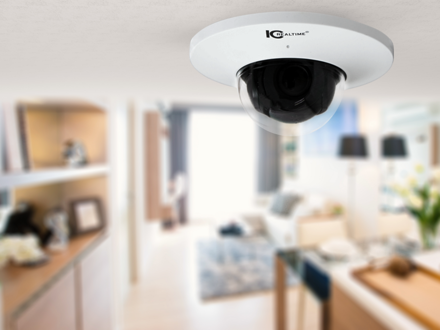 A close-up of a dome-style security camera mounted on the ceiling of a kitchen area.